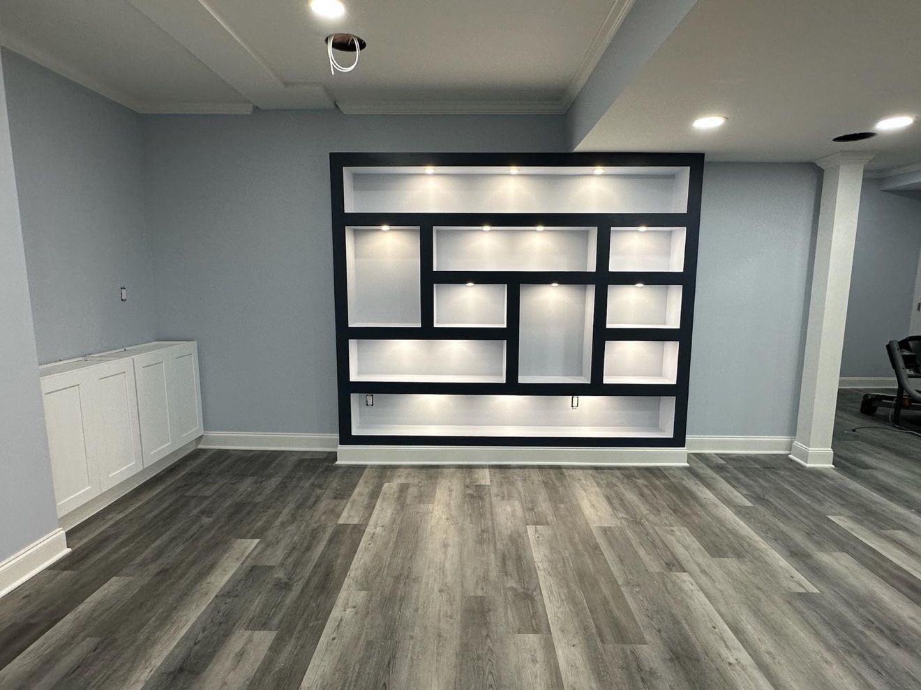 Finished basement with lighted built-in shelves by Stuart Home Improvement